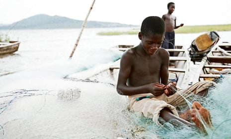 young boy repairing a fishing net