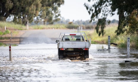 A ute crosses floodwaters on a road