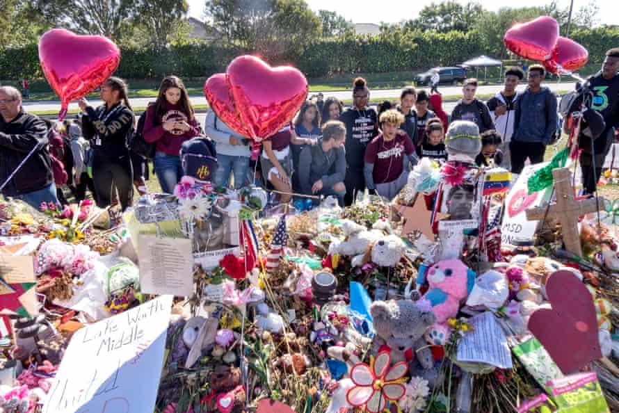 A group of Marjory Stoneman Douglas High School students pray in front of a memorial during the walkout in Parkland, Florida.