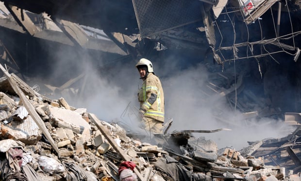 A rescue worker stands in rubble from the Plasco building.