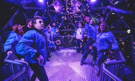 Contestants in a glass dome as part of the Crystal Maze game finale, a new interactive game in London, where they have to grab at foil tickets.