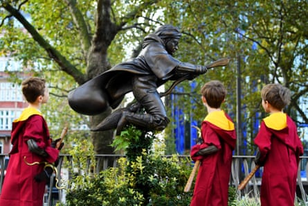 Harry Potter fans Finn and Joey Bruce, and Sam Parker with a new statue of Harry Potter unveiled in Leicester Square, 2020.