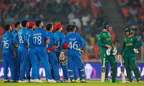 Afghanistan players wait for the third umpire's lbw decision against South Africa's Quinton de Kock (right) during a men's Cricket World Cup match in 2023.