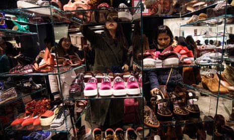 Shoppers look through a collection of shoes during the Boxing Day sale at Selfridges.