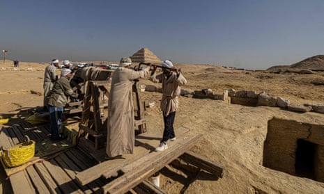 Egyptian antiquities workers dig at the Saqqara archaeological site.