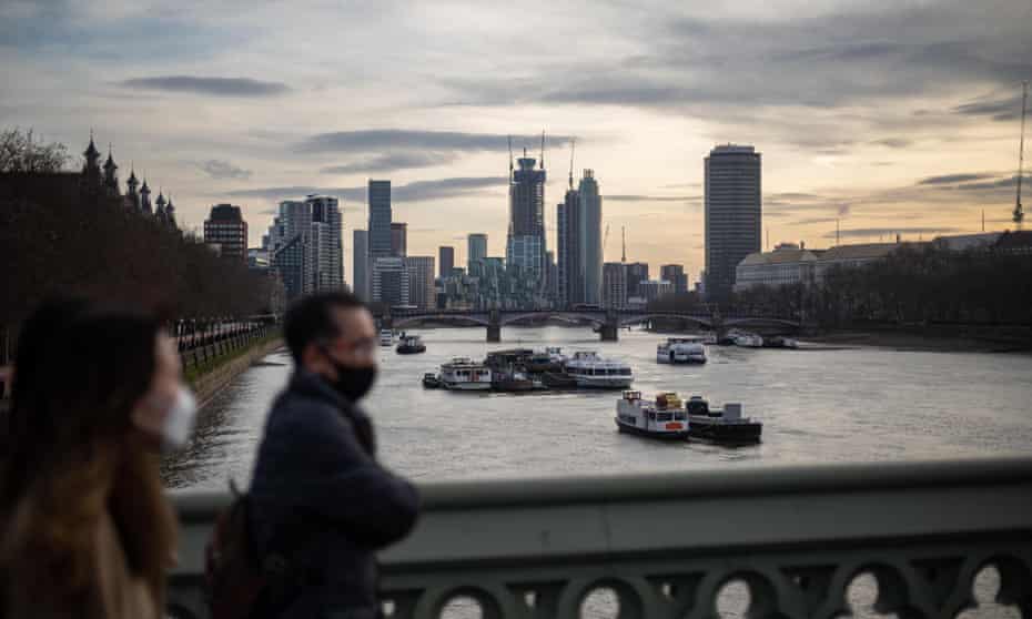 Peoples walk along London Bridge against the West-London skyline this week.