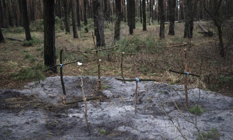 Crosses to honour civilians killed mark a mass grave in the forest of Irpin, on the outskirts of Kyiv.