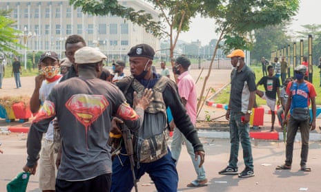 A protester gestures towards a police officer during a protest about legal reforms near the parliament in Kinshasa