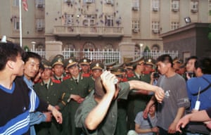 A university student demonstrator throws a rock at the US Embassy in Beijing on 9 May, 1999