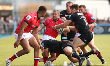Mike Brown (centre) is held up during the defeat by Saracens.