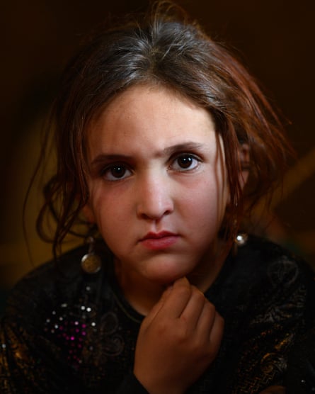 A solemn young girl stares at the camera
