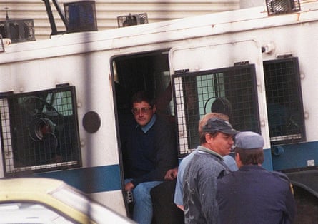 Eugene de Kock stepping out of a vehicle with metal grilles over its windows