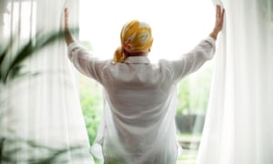 A woman opening curtains