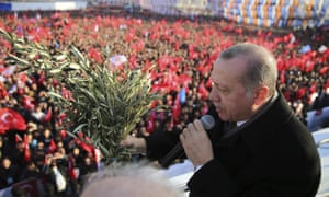 Recep Tayyip Erdoğan holds olive branches as he addresses party members