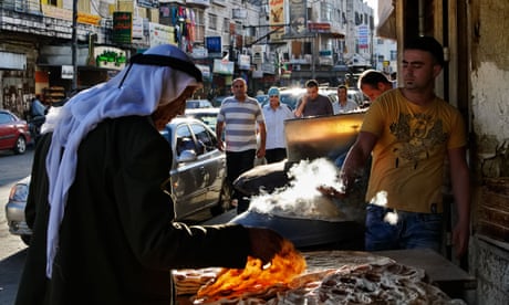 A palestinian in traditional clothing, choosing pita in a street of Ramallah.
