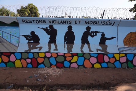 A mural of five silhouetted military figures