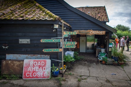 Timber-clad building with a finger-post sign outside with signs including ‘Farmhouse’, ‘Farmyard’, ‘Toilets’, ‘Office’ and ‘Bakery’
