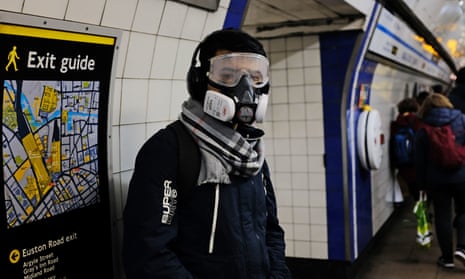 A person wearing a full-face mask in King's Cross underground station