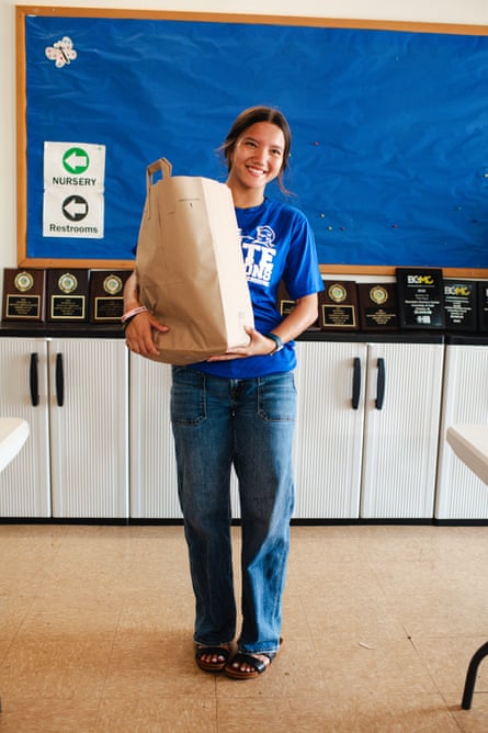 a teenager holding a paper bag