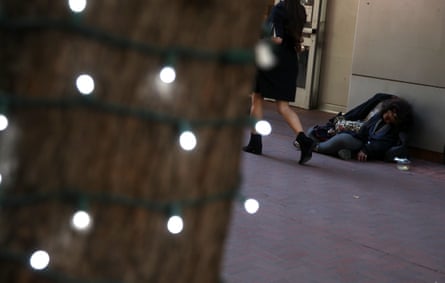 A homeless woman sleeps on the sidewalk in San Francisco.