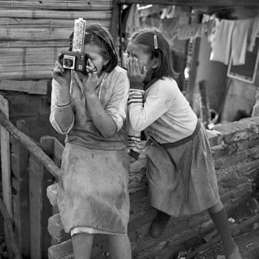 Two young girls learning to use a cameraThe child on the right side of the image covered her eye to look through the camera’s viewfinder.