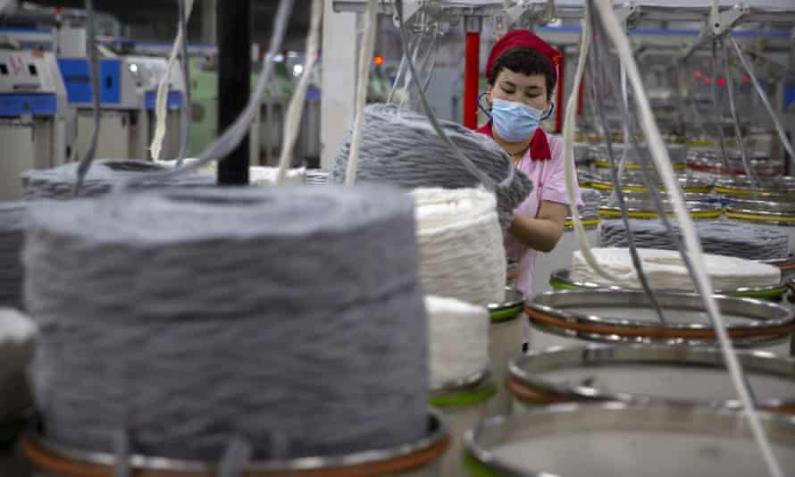 A worker gathers cotton yarn at a textile manufacturing plant, as seen during a government organized trip for foreign journalists, in Aksu in western China’s Xinjiang Uyghur autonomous region.