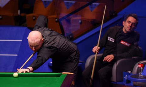 Anthony McGill lines up a shot as Ronnie O’Sullivan watches on at the Crucible