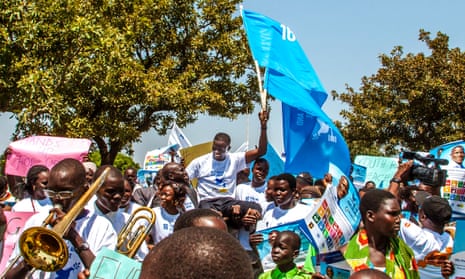 Nobel peace prize nominee Victor Ochen raises a flag in support of the global goal on peace and justice at the memorial site for victims of the Barlonyo massacre in northern Uganda.