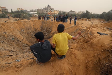 Two Palestinian boys look a huge crater after overnight Israeli bombardment in Rafah.