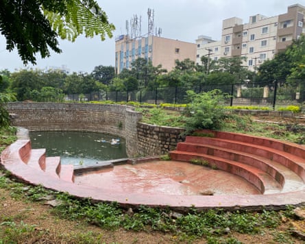 A horseshoe-shape space with four banks of steps and more steps leading down to a large pool surrounded by stone walls a few metres below