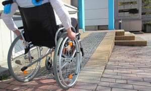 Woman in a wheelchair using a ramp.