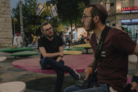 Two young Israeli men sit outdoors talking