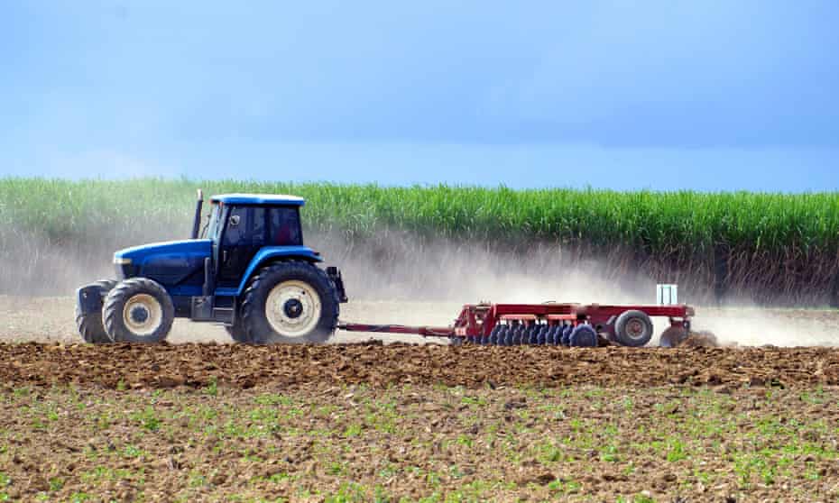 A tractor ploughs a field prior to planting sugarcane in Queensland.
