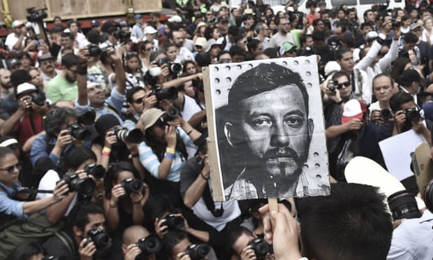 Mexican photojournalists hold pictures of their murdered colleague Ruben Espinoza during a demostration held at the Angel of Independence square in Mexico City. 