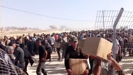 Gunfire heard as thousands rush to receive aid at Gaza distribution centre – video