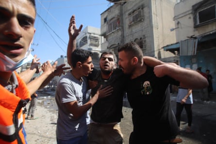 People carry an injured man after Israeli airstrikes in Beit Lahia, Gaza, in October 2023.