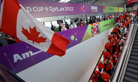 Morocco fans disembark from the metro station, which is also decorated with a Canadian flag, near Al Thumama Stadium