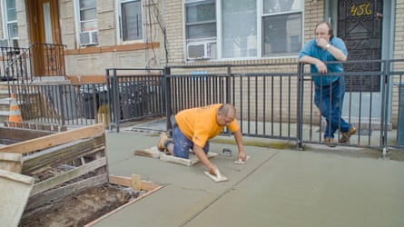 a man kneels on fresh cement