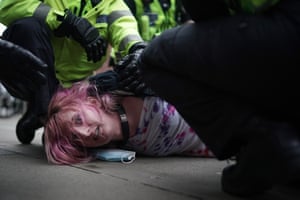A demonstrator is detained by police after blocking the tram tracks during a Kill the Bill protest in Manchester.