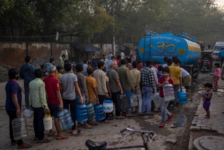 People wait for their turn to collect drinking water from a mobile water tanker on World Water Day in a residential area in New Delhi, India, on Wednesday.