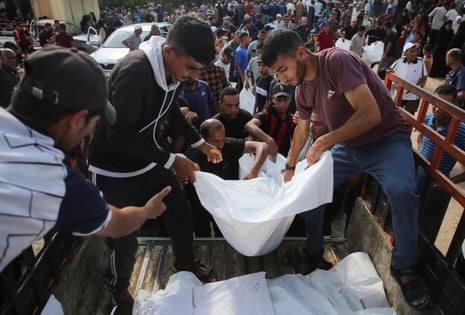 Mourners load bodies on to a vehicle during the funeral of Palestinians killed overnight in Israeli attacks on tents, according to Gaza's health ministry, at Nasser hospital in Khan Younis, southern Gaza Strip, 9 July 2025.