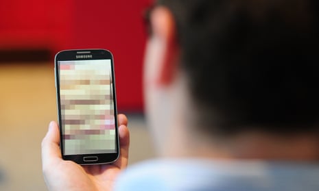 a man looking at a blurred out image on a mobile phone.