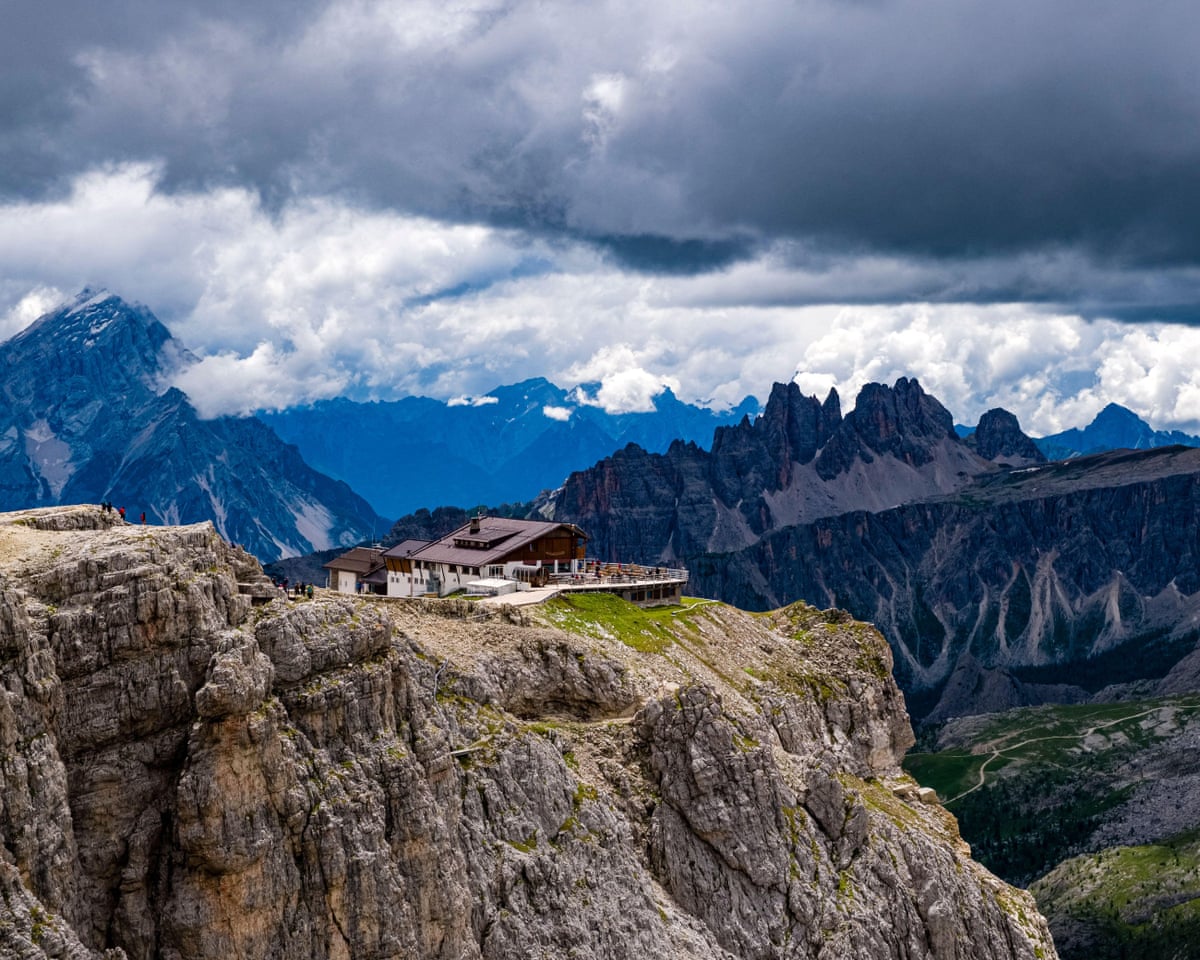 A building on a rocky outcrop overlooking a valley and other mountains