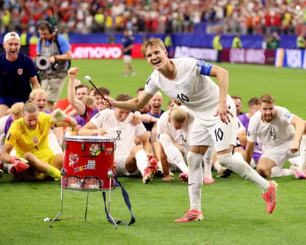 Martin Ødegaard bangs a drum on the pitch
