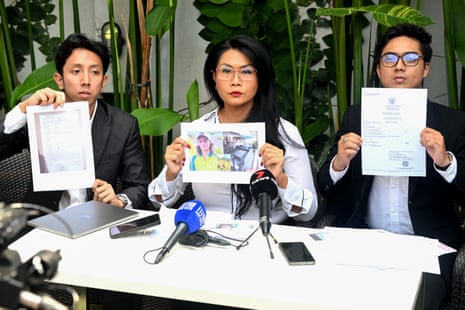 Three people hold up pieces on paper