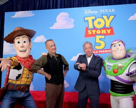 Tom Hanks and Tim Allen pose with Woody and Buzz Lightyear characters at a Toy Story 5 premiere backdrop