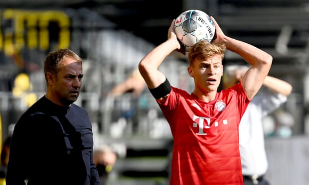 Joshua Kimmich takes a throw-in as his manager, Hansi Flick, looks on.