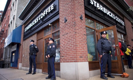 Police officers monitor activity outside as protesters demonstrate inside a Philadelphia Starbucks, where two men were arrested.