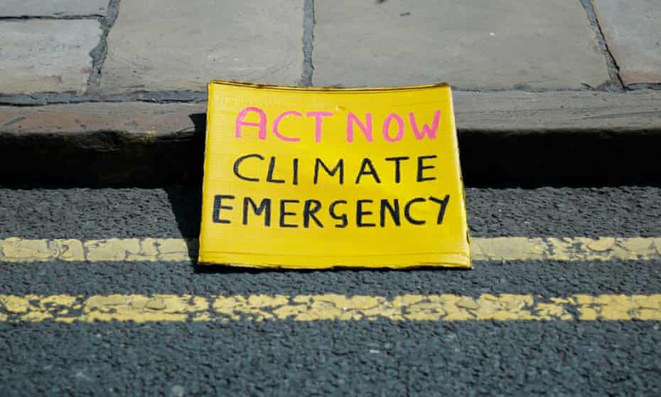 A placard rests on the kerb as members of Extinction Rebellion block the Neville Street Bridge in Leeds