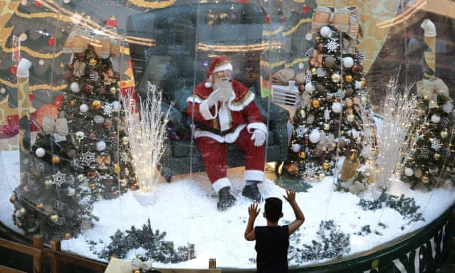 In an emergency, break the glass: a Santa Claus artist greets from behind a screen in Brasilia.
